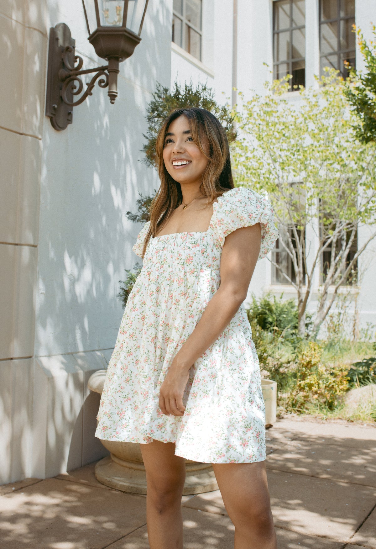 mini cream babydoll dress floral pattern  puff sleeves adjustable flowy pleated criss cross back bow