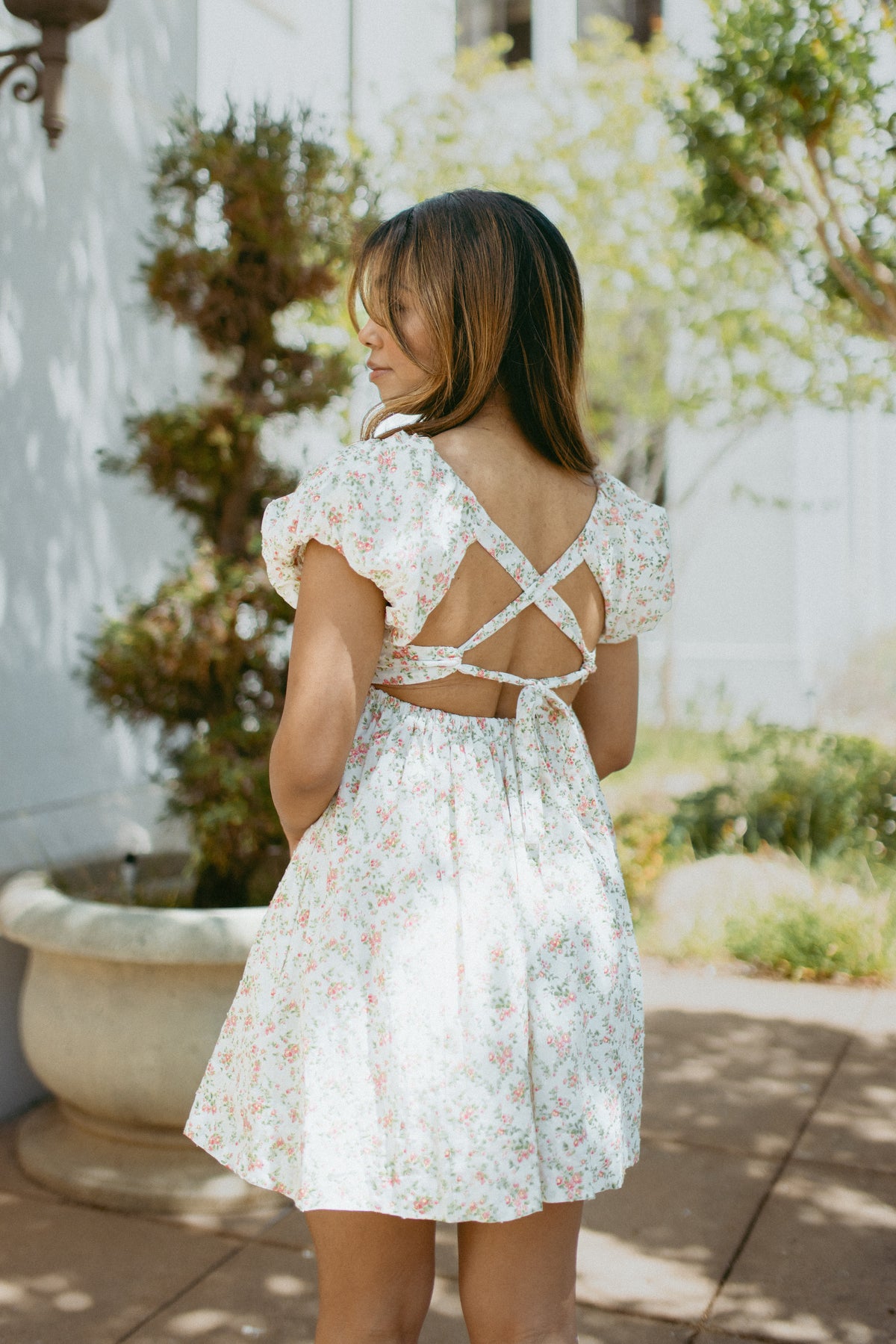 mini cream babydoll dress floral pattern  puff sleeves adjustable flowy pleated criss cross back bow