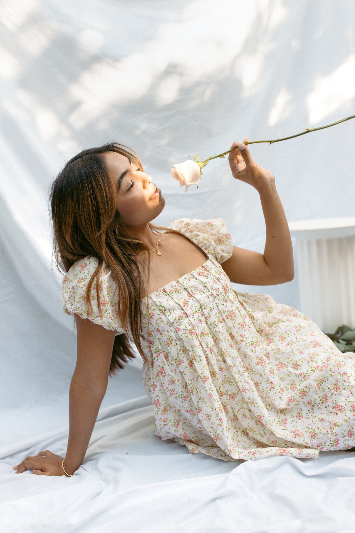 mini cream babydoll dress floral pattern  puff sleeves adjustable flowy pleated criss cross back bow