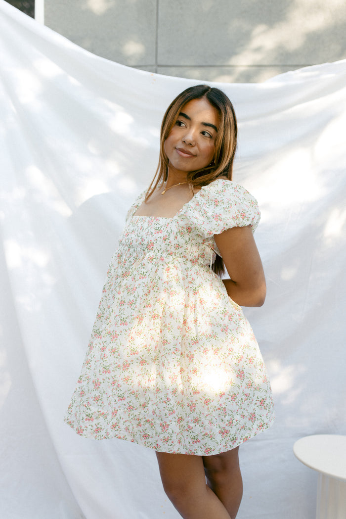 mini cream babydoll dress floral pattern  puff sleeves adjustable flowy pleated criss cross back bow