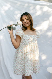 mini cream babydoll dress floral pattern  puff sleeves adjustable flowy pleated criss cross back bow