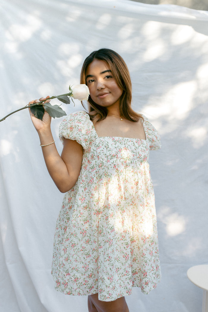 mini cream babydoll dress floral pattern  puff sleeves adjustable flowy pleated criss cross back bow