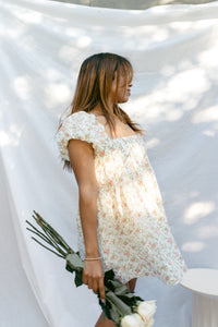 mini cream babydoll dress floral pattern  puff sleeves adjustable flowy pleated criss cross back bow