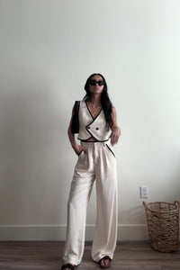 cream high waisted trouser pants relaxed fit black lining accents slight pleating button zipper closure flowy straight leg fit bottoms