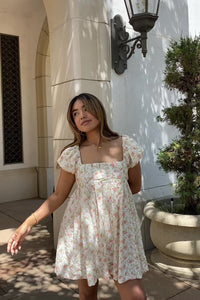 mini cream babydoll dress floral pattern  puff sleeves adjustable flowy pleated criss cross back bow