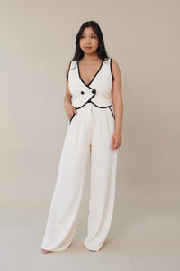 cream high waisted trouser pants relaxed fit black lining accents slight pleating button zipper closure flowy straight leg fit bottoms
