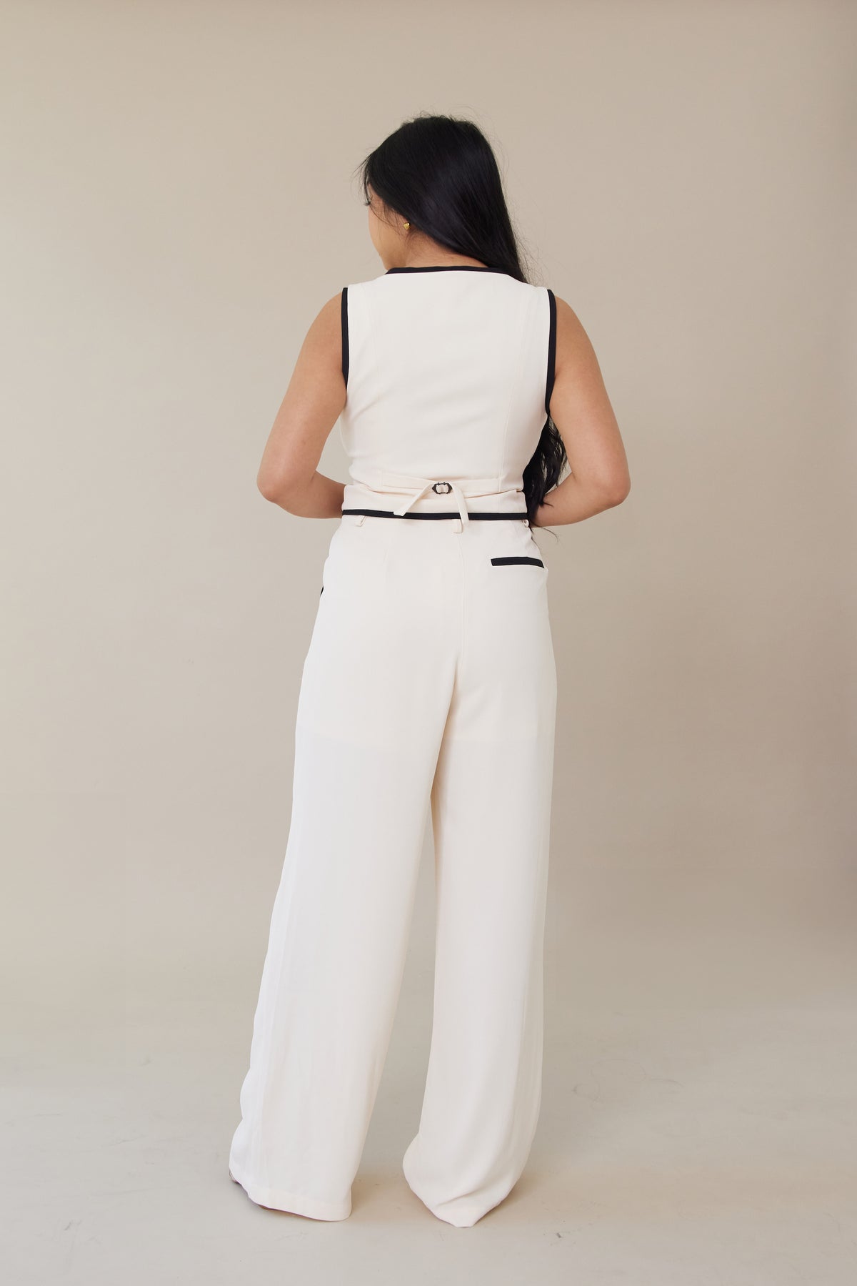 cream high waisted trouser pants relaxed fit black lining accents slight pleating button zipper closure flowy straight leg fit bottoms