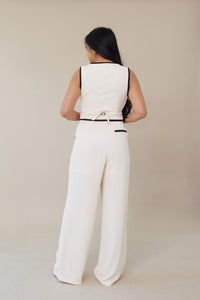 cream high waisted trouser pants relaxed fit black lining accents slight pleating button zipper closure flowy straight leg fit bottoms