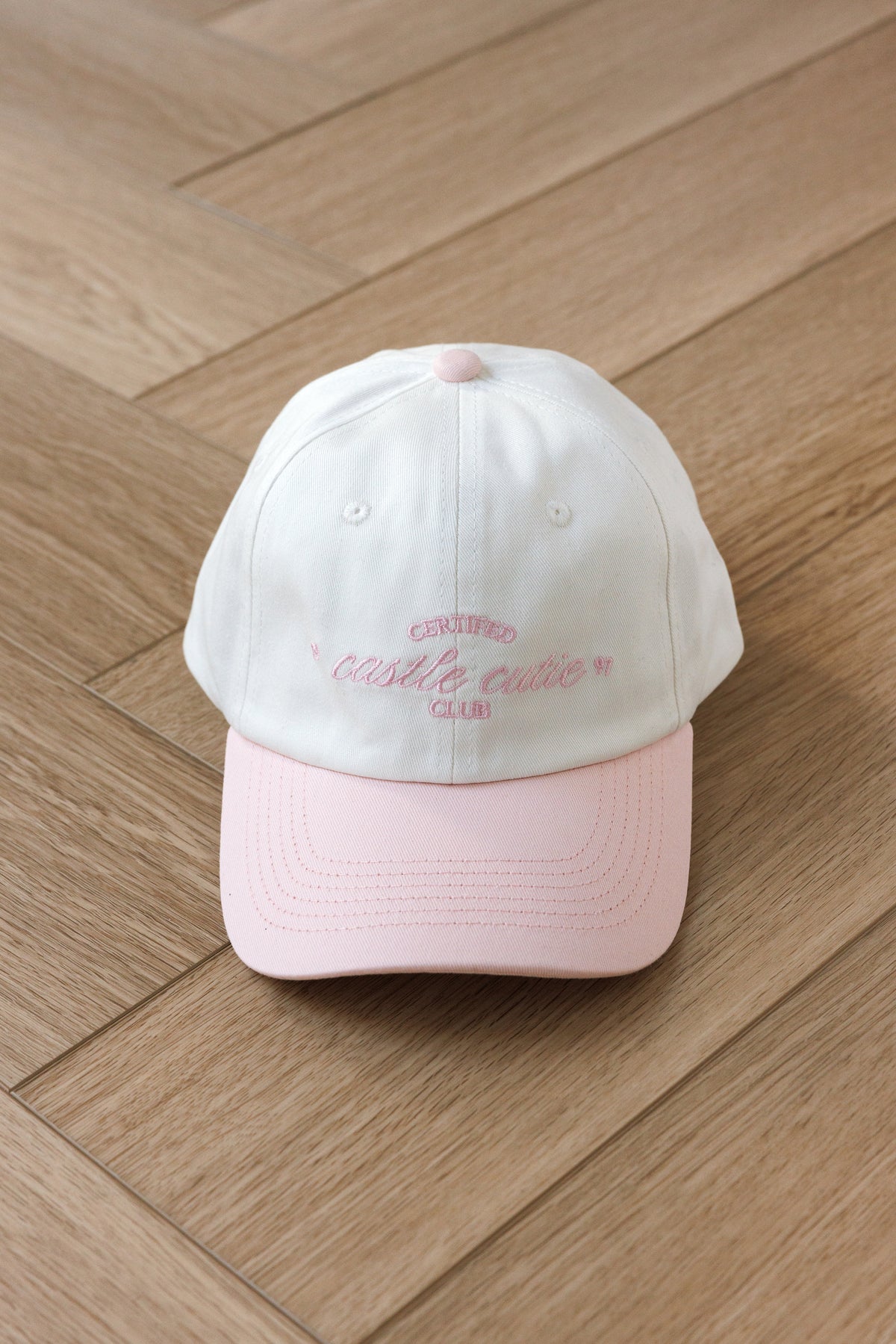 cream colored baseball hat with pink hill embroidered certified castle cutie script pink 1997 embroidered bow on back adjustable ties girly style cap