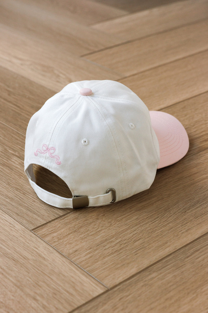 cream colored baseball hat with pink hill embroidered certified castle cutie script pink 1997 embroidered bow on back adjustable ties girly style cap