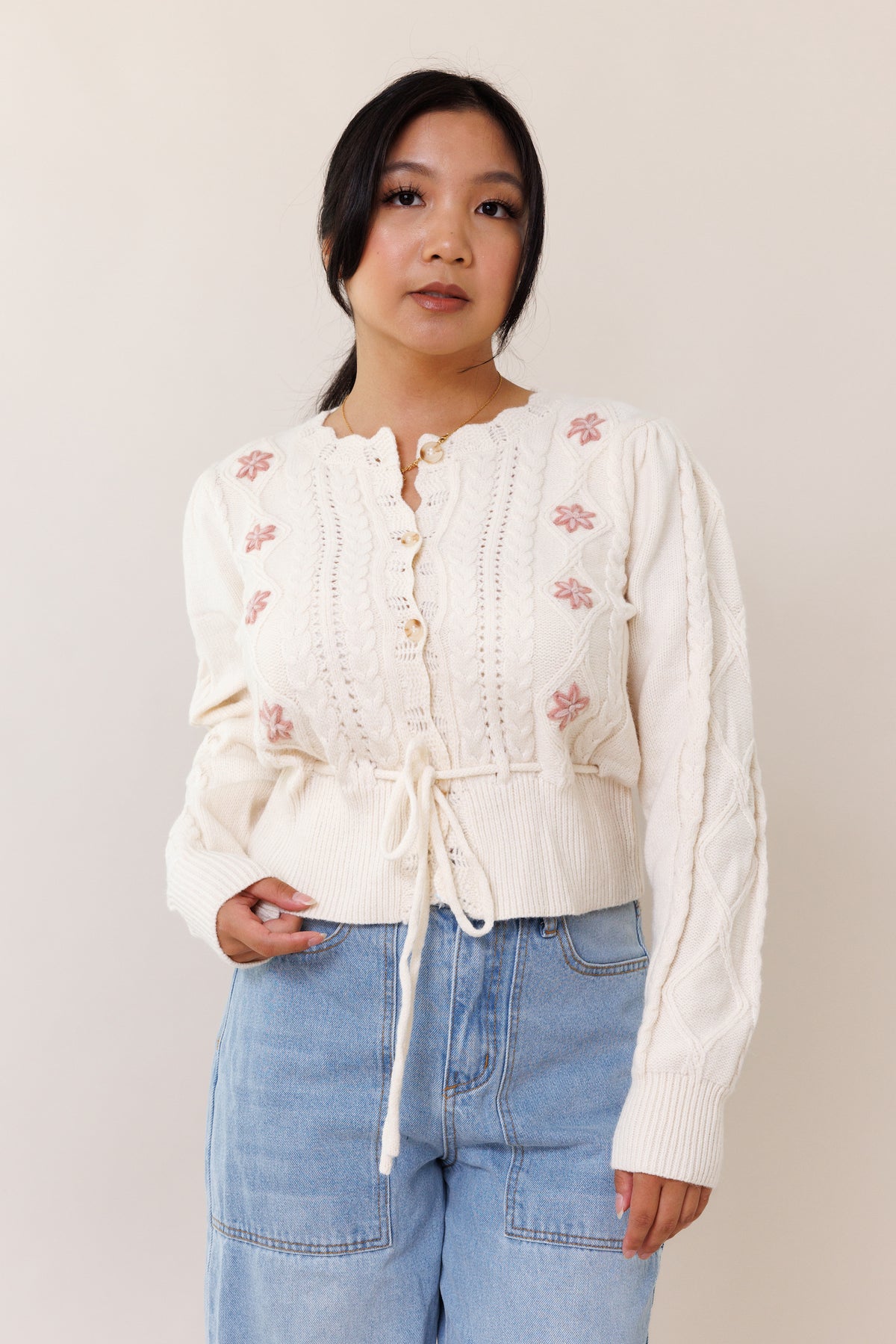 cream knit cardigan sweater long sleeve button front closure adjustable waist front tie floral pink flower ribbed cuffed hems embroidered scallop neckline