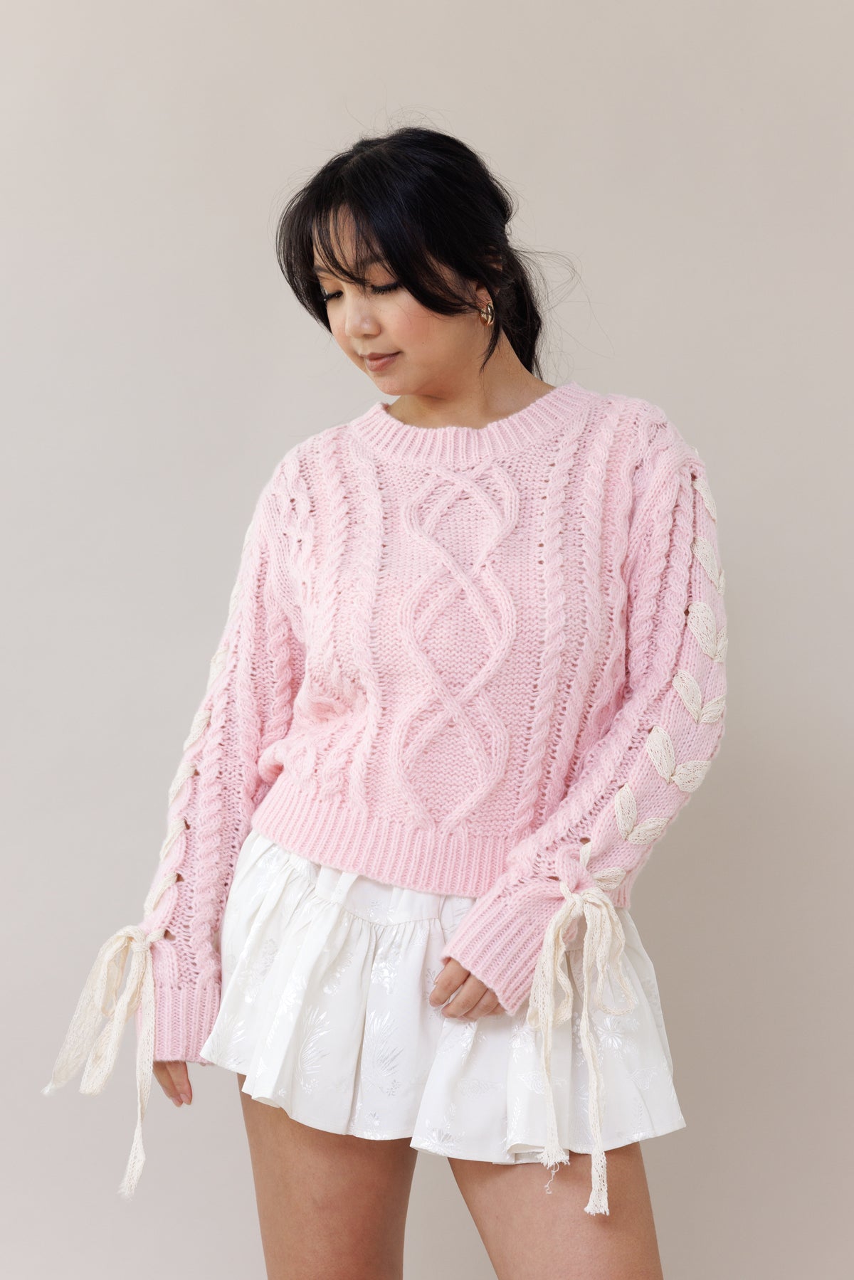 pink cable knit pullover long sleeve sweater round neckline ribbed cuffs lace trim bow romantic fashion cozy wear casual outfit fall winter spring style