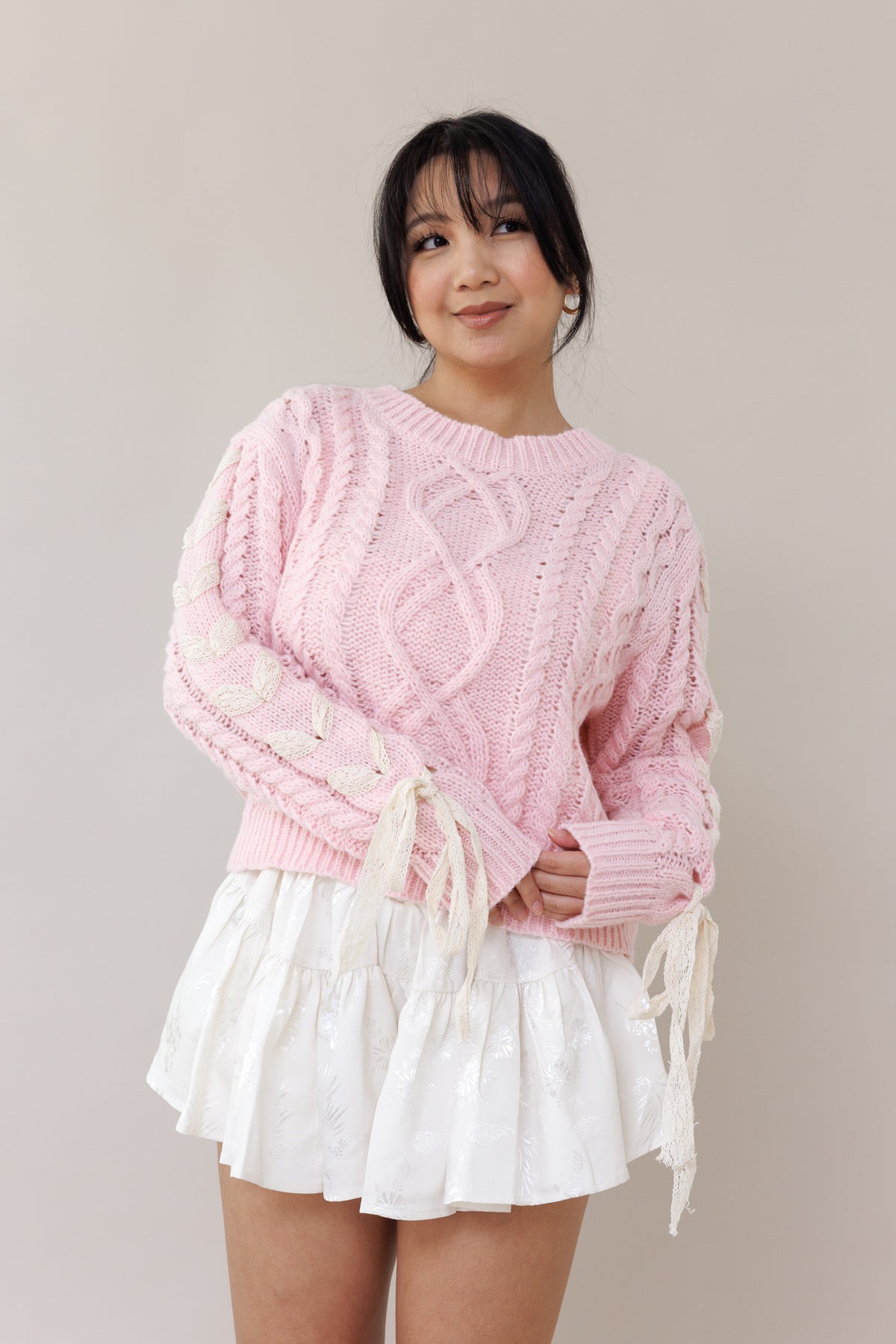 pink cable knit pullover long sleeve sweater round neckline ribbed cuffs lace trim bow romantic fashion cozy wear casual outfit fall winter spring style