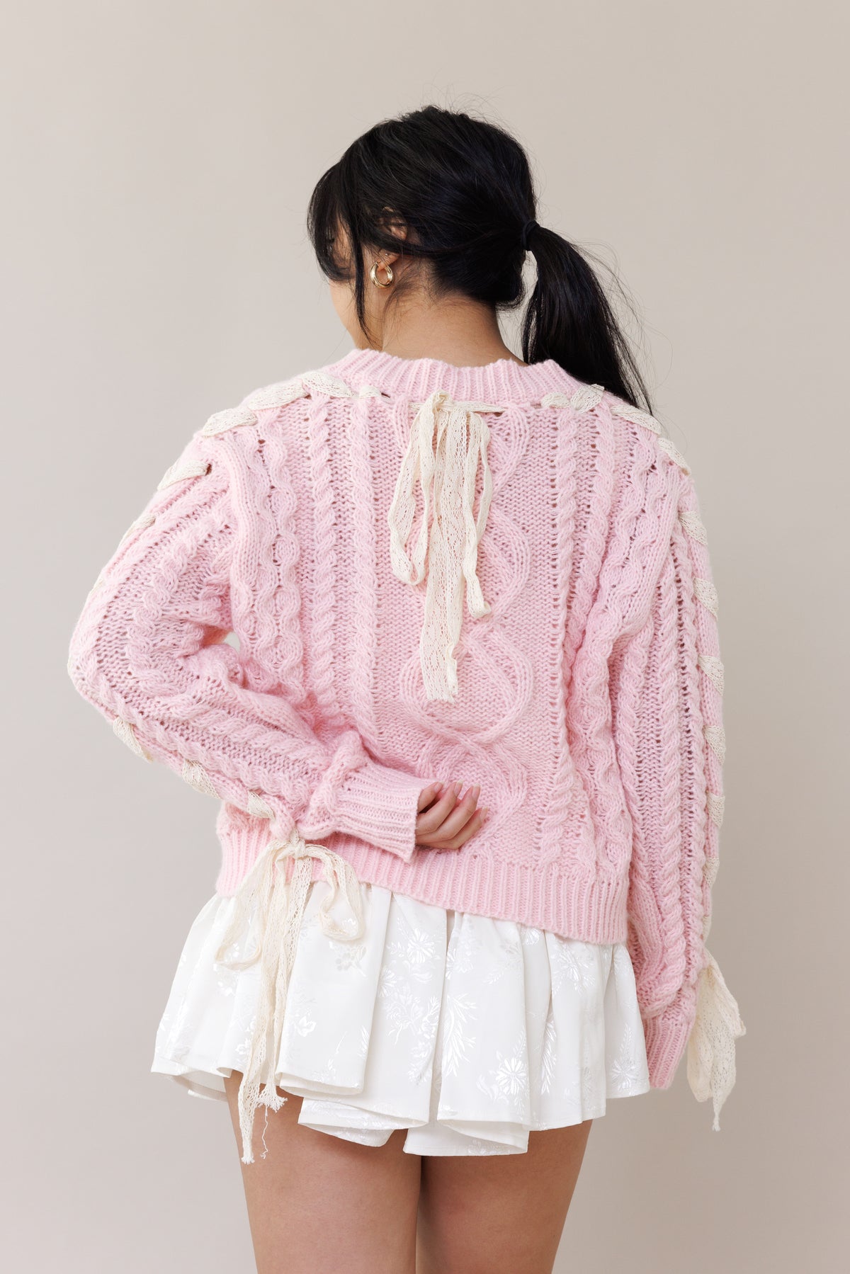 pink cable knit pullover long sleeve sweater round neckline ribbed cuffs lace trim bow romantic fashion cozy wear casual outfit fall winter spring style