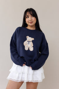 blue knit crewneck sweater long sleeve ribbed cuffs cozy fit cute teddy bear design casual fashion layering street style fall spring winter outfit